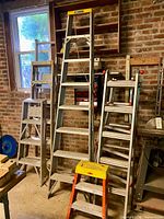 Group of ladders and scaffolding support leaning against brick wall