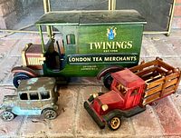 All three vintage toy vehicles grouped on floor