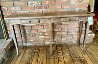 Front view of wooden console table showing two drawers, scalloped apron, cabriole legs