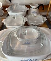 Group of all casserole dishes, roasters, coffee pot and lids