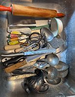 overview of assorted vintage kitchen utensils in sink