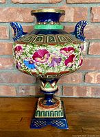 Front view showing floral decoration, handles and pedestal base