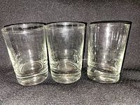 Three straight-sided clear tumblers with thick bases