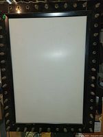 Front view showing white display panel and bulb sockets around frame