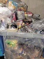 Bulk bin of sealed Happy Meal toys labeled McDonald toys