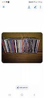 Row of jewel-case CDs on shelf displaying spines