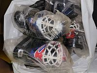 Photo of multiple NHL goalie mask toys still sealed in original plastic packaging showing various teams' colors and logos including New York Rangers, Colorado Avalanche, Montreal Canadiens