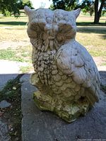 Front view of concrete owl statue showing full figure and moss at base