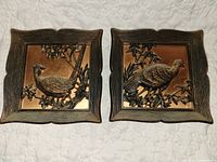 Front view of both plaques showing bird relief designs and frames