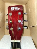 Headstock of Power Play acoustic guitar showing logo and tuners