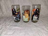 Front view of three Star Wars Empire Strikes Back collector glasses featuring Darth Vader, Luke Skywalker, Boba Fett, and Princess Leia