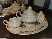 Tea service on floral platter showing teapot, creamer, sugar bowl