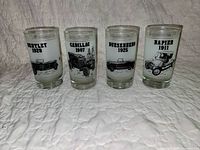 Front view of four glass tumblers showing all car illustrations and text