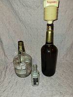 Three bottles grouped: Seagram's with pourer, Schenley O.F.C., Jack Daniel's mini