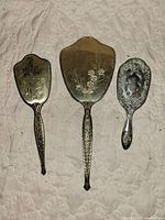 Front view of three-piece vanity set showing embossed backs