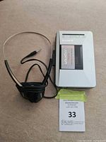 Sony Walkman cassette player with headphones and auction tag visible.