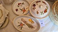 Overview of three dishes: covered dish, oval platter, and scalloped bowl all decorated with Evesham Vale fruit and vegetable designs
