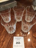Five Mid Victorian cut crystal whisky tumblers arranged on a surface showing their size, shape, and cut pattern.