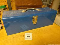 Blue metal toolbox closed, showing latch and handle.