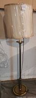 Full view of vintage floor lamp showing base and fabric lamp shade.
