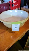 Front view of vintage cream ceramic mixing bowl with sticker labeled 223