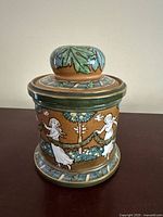 Side view of Morrisian tobacco jar showing figural decoration and overall condition