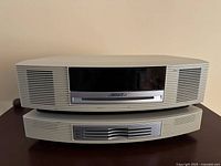 Front view of Bose Wave music system stacked on 3-CD changer