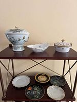 Group shot of lidded bowl, candy dish, Nippon covered dish on upper shelf and decorative plates on lower shelf