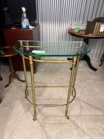 Front view showing brass-tone frame and glass top