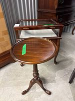 Round Gibbard pedestal side table in front of Bombay display table