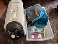 Overall lot showing Vittles Vault, bin with coats, packaged harness, Pawz boots and tool