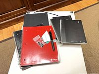 Group shot of notebooks, folio, pen and refills