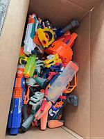 Box filled with mixed Nerf blasters and parts