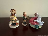 All three porcelain figurines displayed side by side
