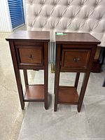 Front view of both wooden side tables showing drawers and shelves