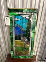 Full view of stained glass panel with heron scene and hanging chains