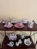 Overall view of teacups, teapot, dish and figurine on shelving