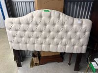 Front view of cream tufted queen headboard