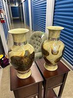 Both cream marbled vases on stands showing size and matching design