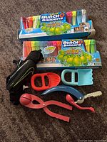 All items laid out: two Bunch O Balloons boxes, Nike shin guards, snowball makers, sand tools