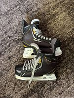 Side view of both Bauer Supreme One.6 youth skates showing overall condition