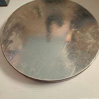 Closed round box showing reflective silver lid