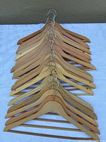 Stack of 21 wooden hangers showing shape, hooks, and bars