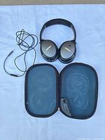 Headphones, audio cable and open carrying case displayed