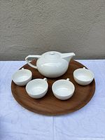 Full view of teapot, four cups, wood tray