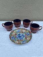 Group shot of four Denby cups and one Otagiri plate, front view