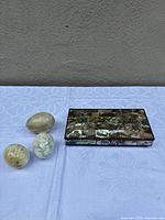 Overall lot showing three marble eggs and closed abalone tile box
