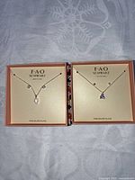Two boxed FAO Schwarz necklace and earring sets