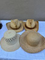 All four straw hats grouped on table