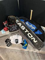 Lot overview showing Rawlings and Easton bat bags, packaged accessories, glove, ball, pants, and gloves